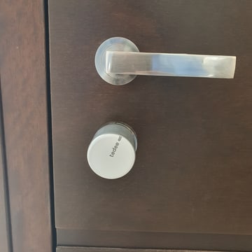 Cerradura inteligente motorizada instalada en una puerta de vivienda