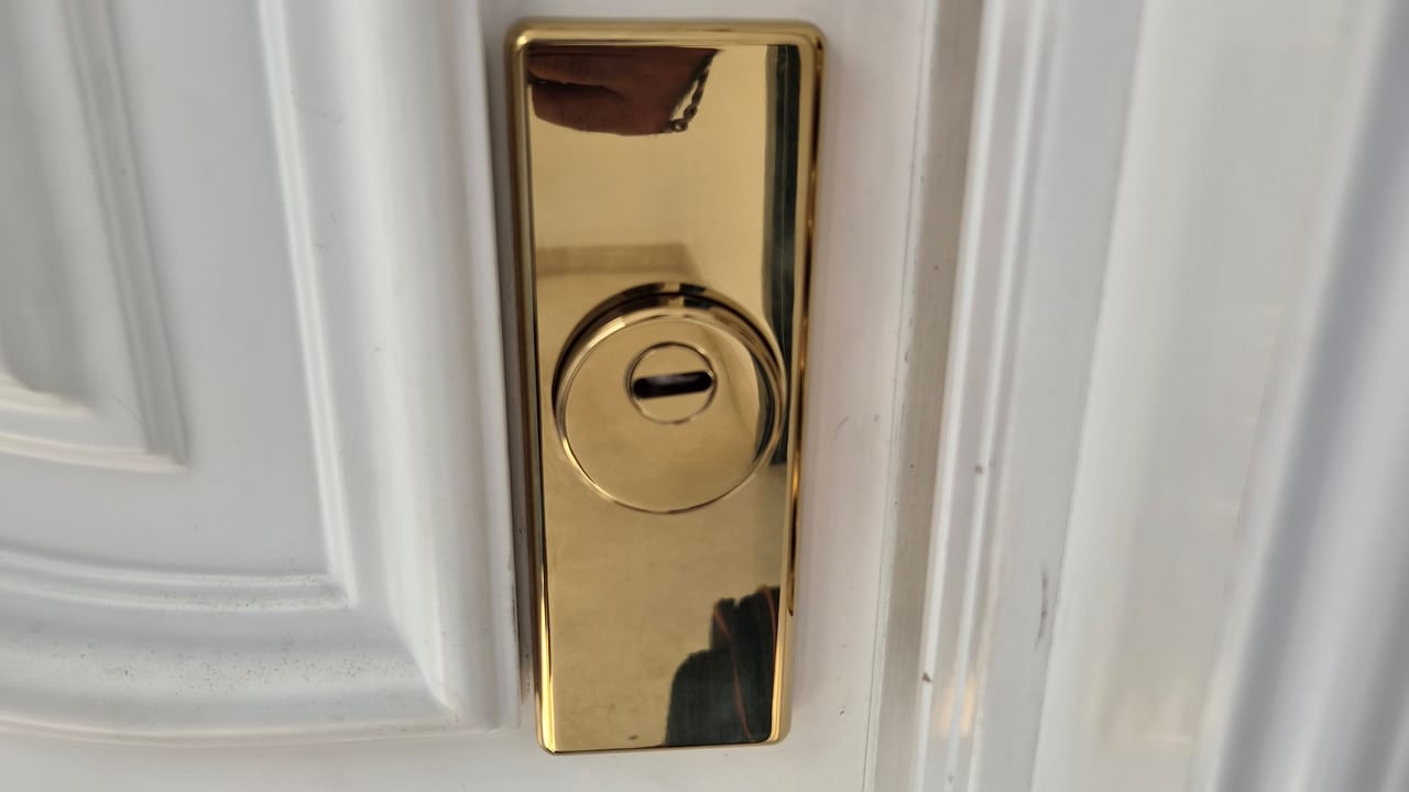Escudo de seguridad dorado en la cerradura de una puerta